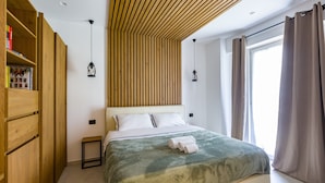Une chambre à coucher avec un lit, une armoire en bois et une fenêtre avec des rideaux.