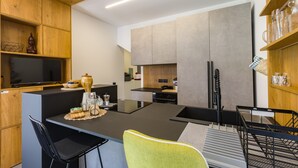 Eine moderne Küche mit Kochinsel, Holzschränken und einem Essbereich mit Stühlen.