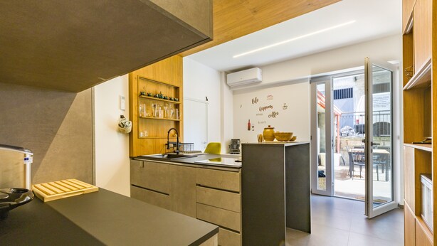 Eine moderne Küche mit Einbauofen, Spüle und einem Holzboden mit Gläsern.