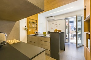 Eine moderne Küche mit Einbauofen, Spüle und einem Holzboden mit Gläsern.