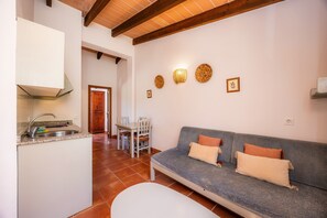 A compact living space with a kitchenette, a sofa, and a dining area.