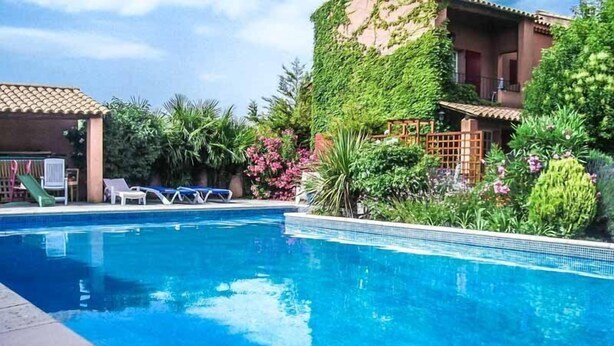 A swimming pool with clear blue water, surrounded by lush greenery and a building with a tiled roof. - Courthézon near Avignon, holiday villa, swimming pool, beautiful park. (COURTHEZON)