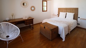 A bedroom with a wooden bed, a wicker chest, a desk, and a chair. - Exceptional landhouse, not overlooked, large pool, Noves, Alpilles, pets allowed (2). (NOVES)