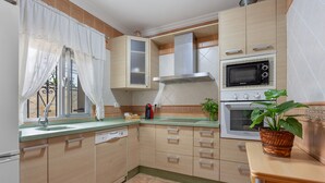 A kitchen with a microwave, stove, sink, and cabinets.