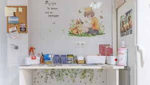 A bulletin board with notes, a corkboard, and a wall with a floral pattern.