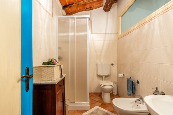 Un baño con ducha, inodoro, bidé y lavabo.