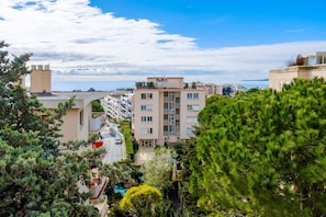 A multi-story building with balconies, a clear sky, and a view of the sea. - Bright 1-Bedroom Apartment with Sea View, 10 Minutes from the Beach (Cagnes sur Mer)
