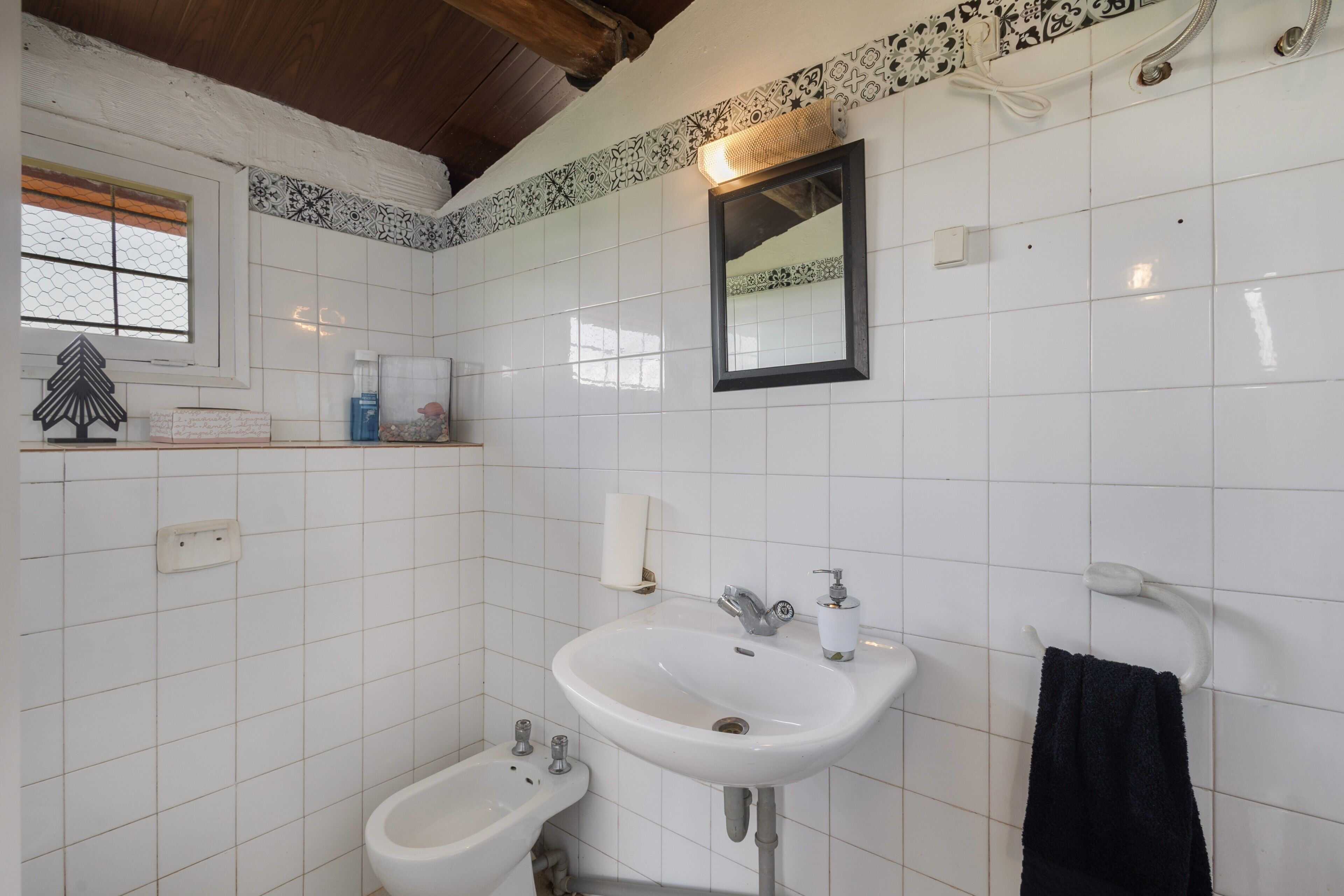 A bathroom with a white sink, bidet, and a mirror.