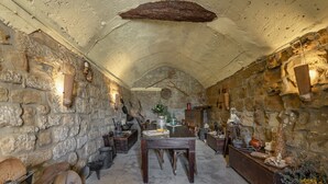 A stone-walled room with a wooden table and benches, stone walls, and a vaulted ceiling. - Country House 'Masia Manonelles' with Private Pool, Terrace & Air Conditioning (Unknown)