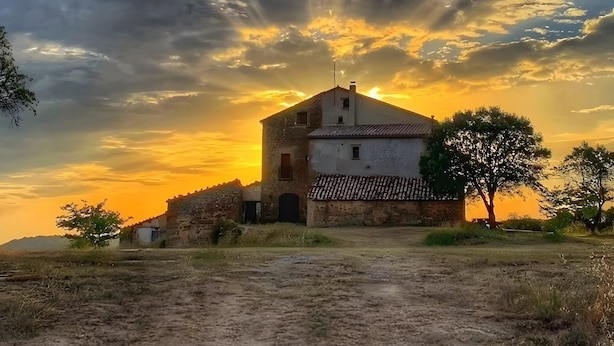A rustic building with a sloped roof, a small chimney, and a dirt path leading to it. - Country House 'Masia Manonelles' with Private Pool, Terrace & Air Conditioning (Unknown)