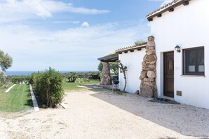 Un edificio blanco con un pilar de piedra, una puerta y una ventana.