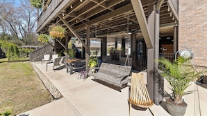 An outdoor seating area with a wooden bench, chairs, and hanging plants. - Downtown Estate Property close to Southeastern (Hammond)