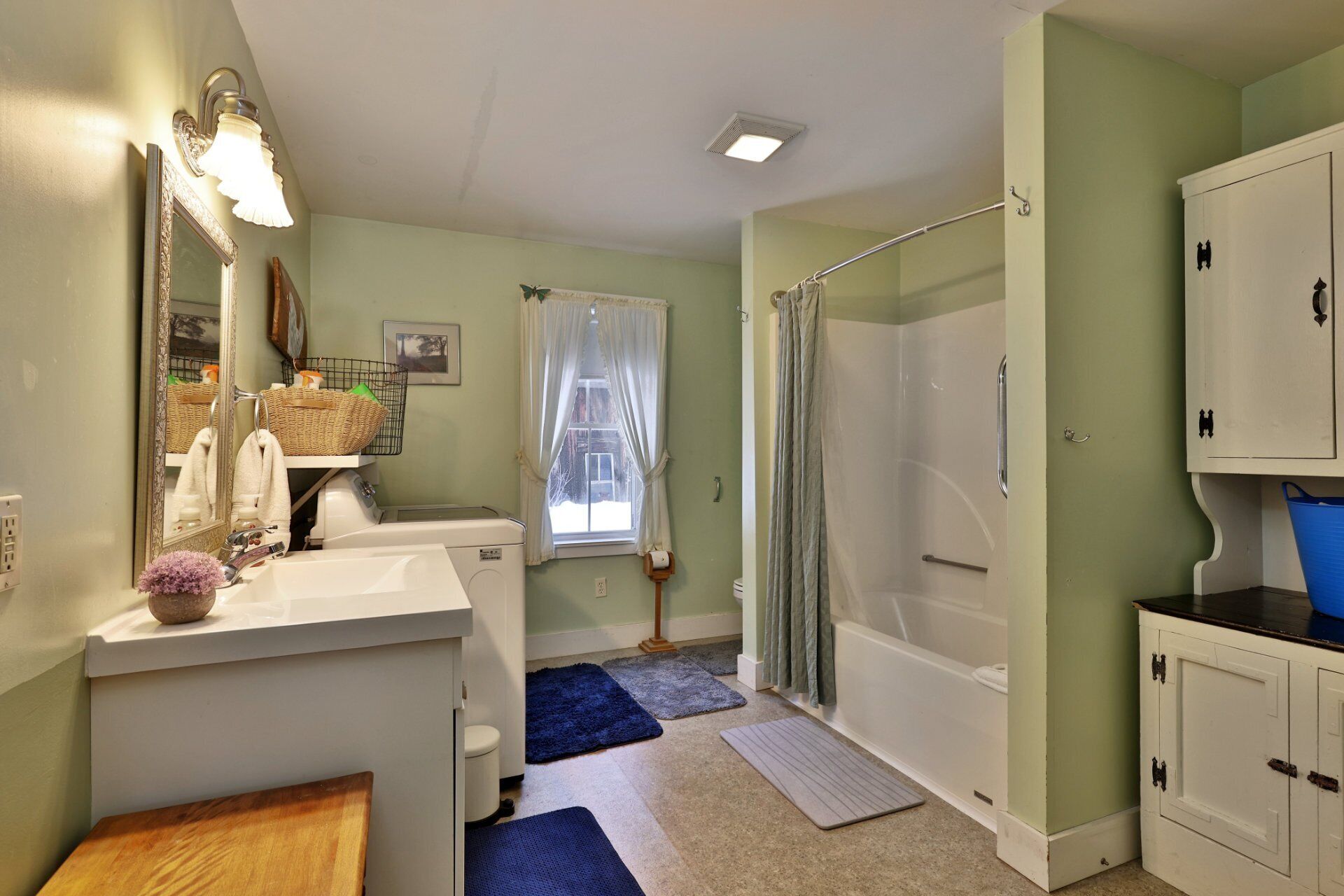 Ein Badezimmer mit Dusche, Waschbecken, Spiegel und Toilette.