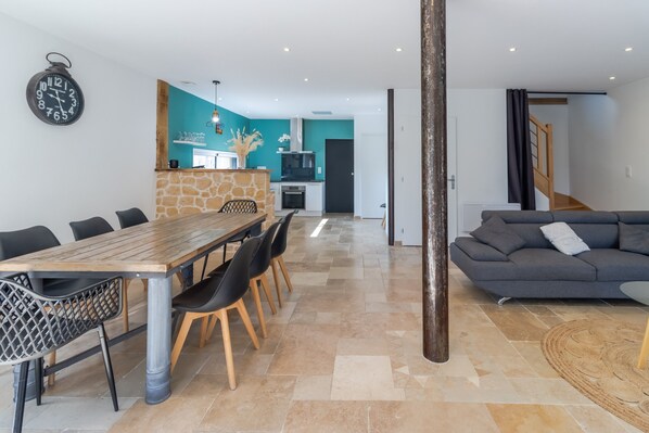 Un espace de vie moderne comprenant un coin repas, une cuisine et un escalier.