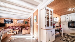 A wooden interior with a dining area, kitchen, and living space. - Chalet 'Phidel - 11 People' with Mountain Views, Private Terrace, and Wi-Fi (Bernex)