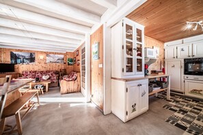 Un intérieur en bois comprenant un coin repas, une cuisine et un espace de vie.