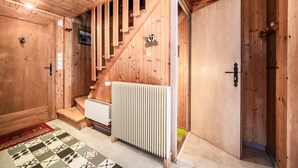 A wooden interior with a staircase, a radiator, and a door. - Chalet 'Phidel - 11 People' with Mountain Views, Private Terrace, and Wi-Fi (Bernex)