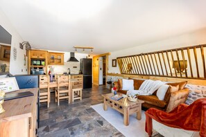 Uma sala de estar moderna com um sofá, mesa de centro e área de jantar.