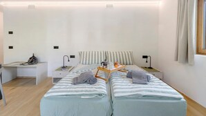 A bedroom with two beds, a desk, a nightstand, and a window with curtains. - Studio 'Pino Mugo' with Mountain View, Balcony and Wi-Fi (Livigno)