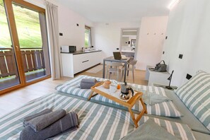 A modern room with a bed, a small table with a kettle, a laptop, and a chair. - Studio 'Pino Mugo' with Mountain View, Balcony and Wi-Fi (Livigno)