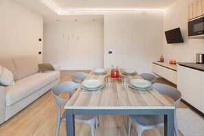 Een moderne eetruimte met een houten tafel voor vier personen, omringd door grijze stoelen.