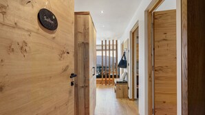 Un pasillo interior de madera con un letrero que dice 'Salbei', un banco y vistas a través de una ventana.