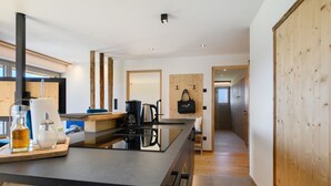 Cocina moderna con una isla central, detalles de madera y vista al área de estar.