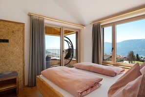 Une chambre avec un lit, une chaise et une vue sur les montagnes.