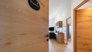 Un interior de madera con un letrero que dice 'Thymian', una zona de cocina con muebles modernos y un piso de madera.