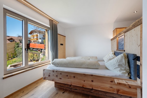 Une chambre avec un lit, de grandes fenêtres et une vue sur l’extérieur.