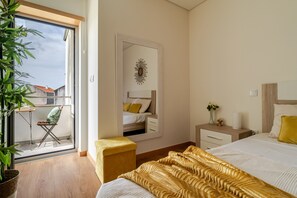 A bedroom with a bed, a nightstand, a mirror, a window, and a balcony with a chair and a plant. - Apartment 'Estrelinha Do Mar' with Shared Pool, Wi-Fi and Air Conditioning (Apúlia)