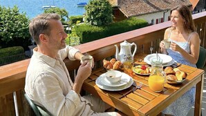 A terrace with a table set for breakfast overlooking a lake with boats and mountains in the background. - Concierge, Lake Thun/Alps Scenic Views by SwissHut (Hilterfingen)