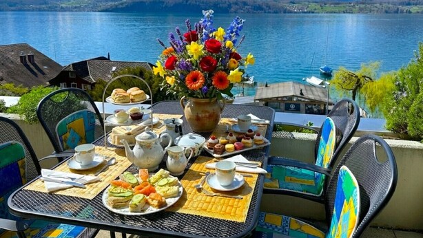 A table set for tea and snacks with a mountain view in the background.