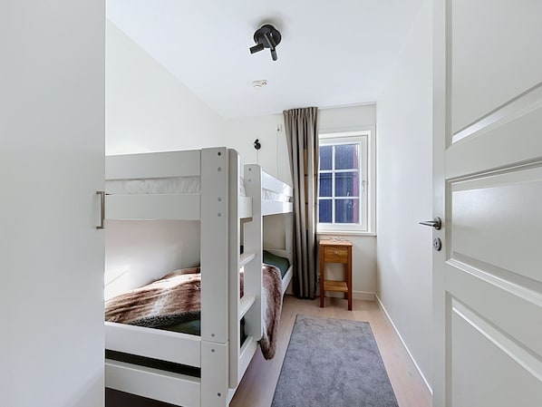 A room with bunk beds, a desk, a chair, and a window with curtains. - Trillevallen 4 by Interhome (Trillevallen)