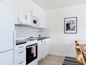 A modern kitchen with white cabinetry, a built-in microwave, a dishwasher, and a stove.