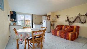 Un espacio habitable compacto con comedor, cocina y sofá.
