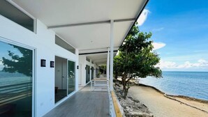 A modern building with a covered walkway leading to a beach. - Mandala Beach Cebu by Hiverooms (Daanbantayan)