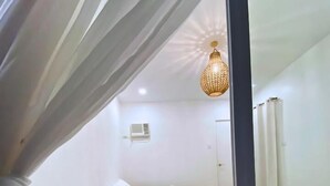 A room with two beds, a ceiling fan, and a hanging light fixture. - Mandala Beach Cebu by Hiverooms (Daanbantayan)