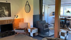 Una sala de estar acogedora con chimenea, televisión y asientos cómodos.