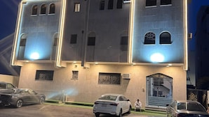 Un edificio de varios pisos con entradas iluminadas y acceso despejado.