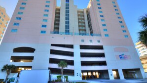 Um hotel com vários andares, átrio central e estacionamento.
