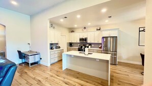 A modern kitchen with white cabinetry, stainless steel appliances, and a herringbone tile backsplash. - Highlands Reserve Villa with screened-in patio & pool. Peaceful Golf Community. (Davenport)