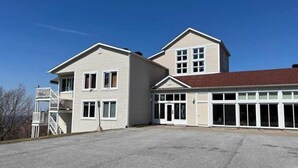 A two-story building with a garage and a covered parking area.