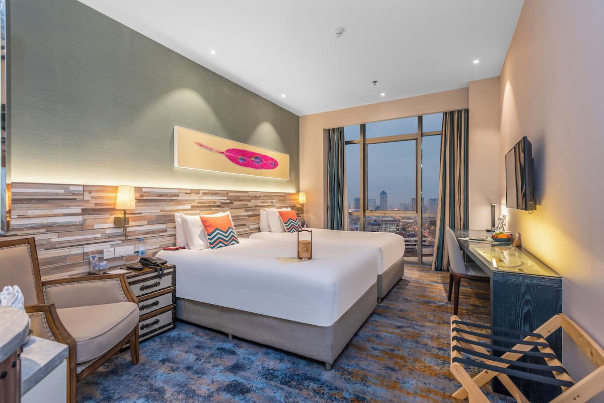 Una habitación de hotel con una cama grande, un escritorio, una silla, un aparador y un televisor.