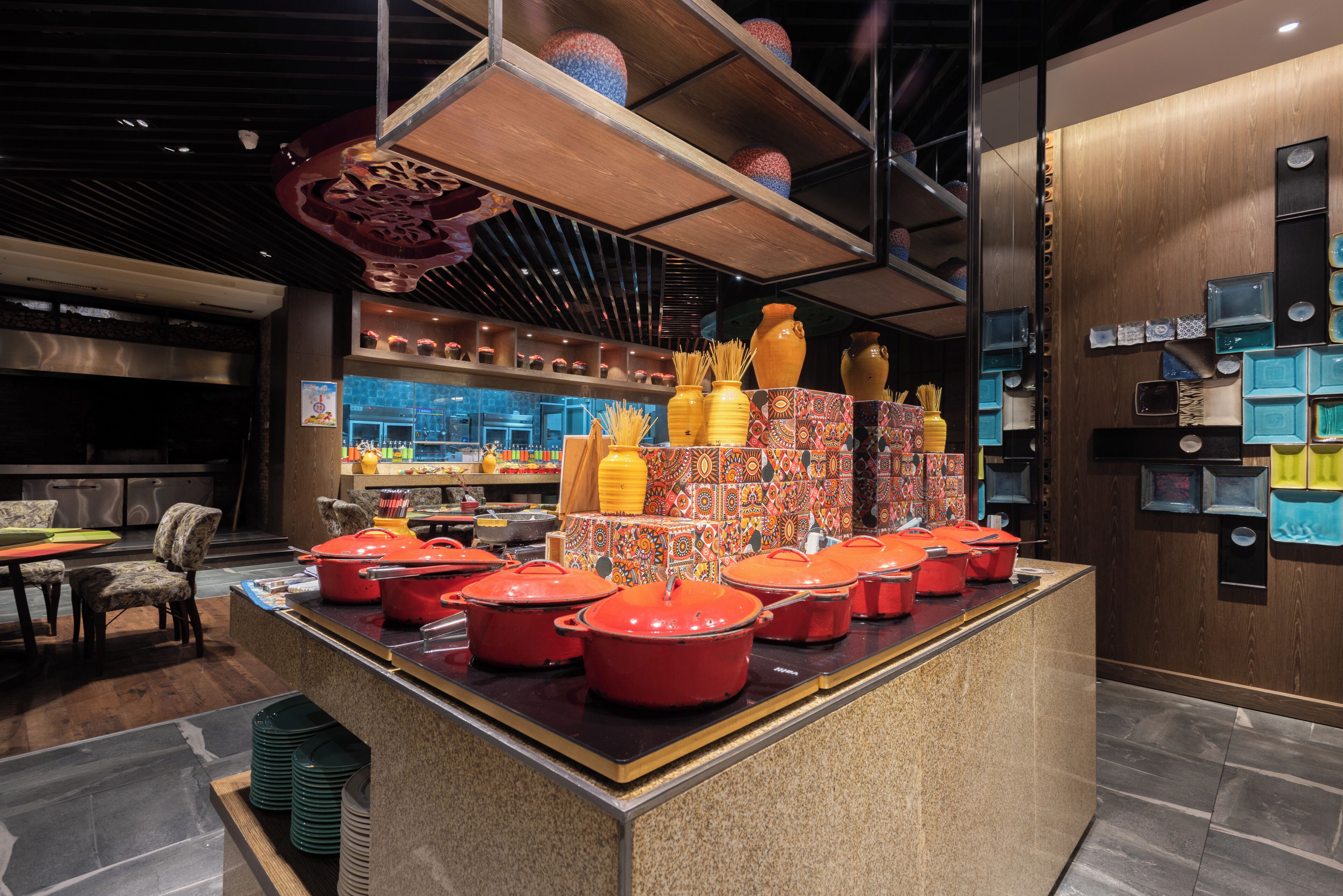 A kitchen area with a central island displaying red pots and various kitchen utensils.