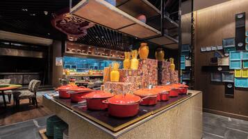 A kitchen area with a central island displaying red pots and various kitchen utensils.