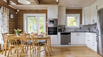 Une cuisine moderne avec un plancher en bois, des armoires blanches et des appareils électroménagers en acier inoxydable.
