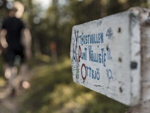 Un letrero desgastado con texto en idioma extranjero, sujeto a un poste.