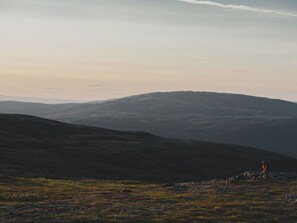 Un paisaje montañoso con una persona caminando.