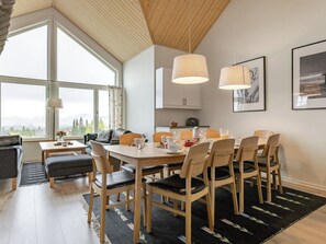 Un intérieur moderne comprenant un coin repas, une cuisine et un espace salon.
